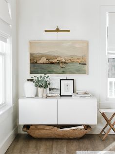 a white room with a painting on the wall