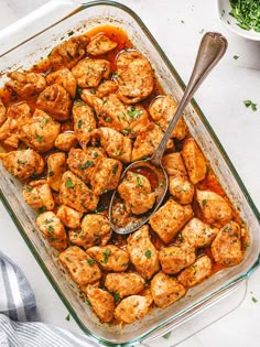 a glass casserole dish filled with chicken and garnished with parsley