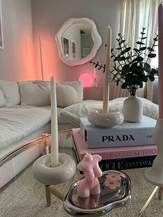 a living room filled with lots of furniture and books on top of a table in front of a white couch