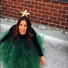 a woman wearing a green tutu skirt and a star headband