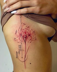 a woman's stomach with a flower tattoo on her side and the words written in chinese