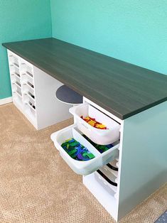 a kitchen counter with two bins on the bottom and an open drawer underneath it