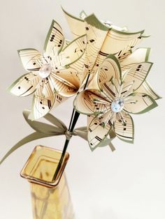 an origami flower in a vase with music notes