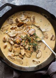 a skillet filled with mushroom soup on top of a table