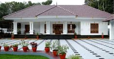 a white house with red potted plants in front