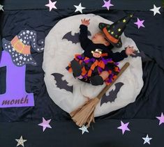 a baby in a witches costume laying on top of a table