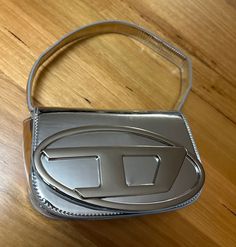 Diesel 1DR Bag in Silver - Like new condition - No flaws or scratches - Comes with shoulder strap. box and dust bag, - No refunds - No uses and returns Modern Silver Shoulder Bag With Logo Hardware, Silver Bags With Logo Hardware For Formal Occasions, Formal Silver Bags With Logo Hardware, Designer Silver Bags With Logo Hardware, Silver Shoulder Bag With Logo Hardware For Everyday Use, Trendy Rectangular Shoulder Bag With Logo, Trendy Formal Shoulder Bag With Logo, Silver Bags With Logo For Everyday Use, Trendy Rectangular Shoulder Bag With Logo Hardware