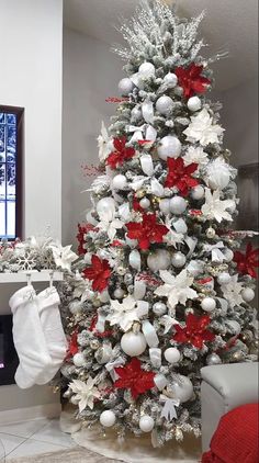 a white christmas tree with red and silver ornaments