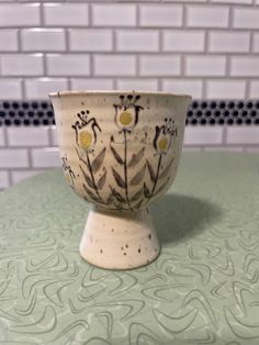 a white bowl sitting on top of a green table