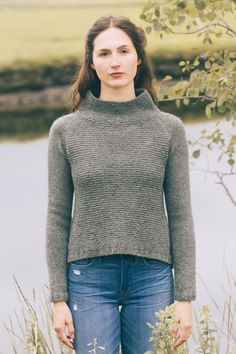 a woman standing in front of some tall grass