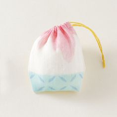 a small bag sitting on top of a white table next to a toothbrush holder