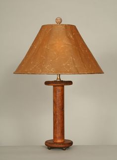 a lamp that is sitting on top of a table next to a light fixture with a brown shade