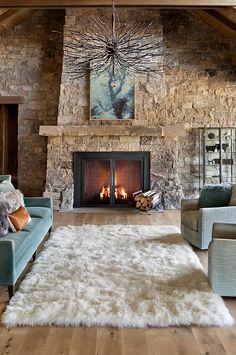 a living room filled with furniture and a fire place next to a stone wall fireplace