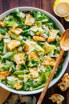 a salad with bacon and lettuce in a wooden bowl on a checkered tablecloth