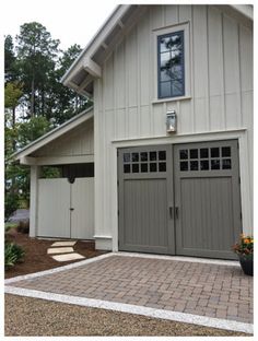 a garage with two doors and brick walkway