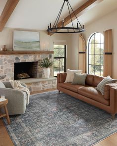 a living room filled with furniture and a fire place in the middle of an open floor plan