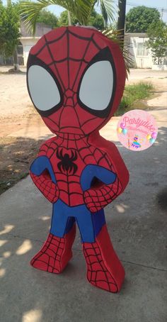 a cardboard cut out of spiderman on the sidewalk with palm trees in the background