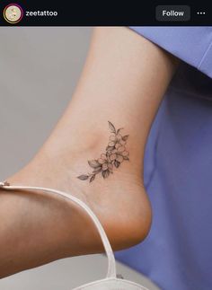 a woman's foot with a flower tattoo on the side of her leg and an arrow