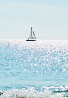 a sailboat in the ocean on a sunny day