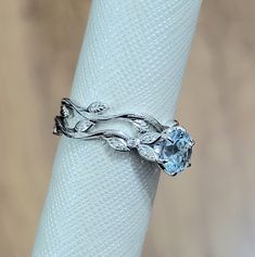 a close up of a ring on top of a white napkin with a blue stone