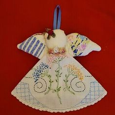 an embroidered angel ornament with flowers on it