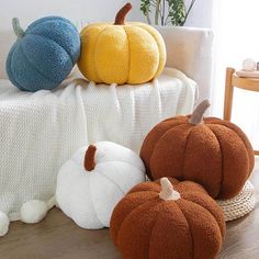 three pumpkins sitting on top of a table next to a white cloth covered chair