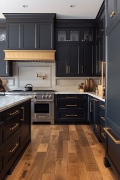 a kitchen with black cabinets and wood floors