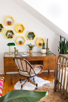 a room with wooden floors and lots of potted plants on top of the desk