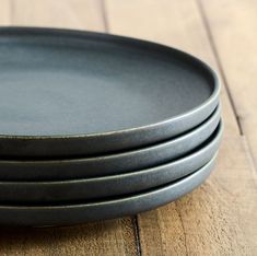 four black plates stacked on top of each other