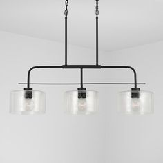 three lights hanging from a ceiling fixture in a room with white walls and flooring