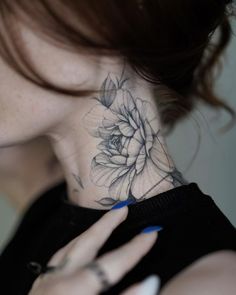 a woman with a flower tattoo on her neck