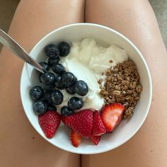 a bowl of yogurt, strawberries and granola is seen from above