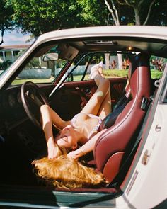 a woman laying in the back seat of a car