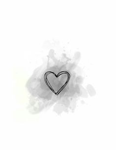 a black and white heart pin sitting on top of a white surface with watercolor spots