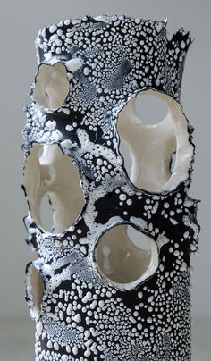 a black and white vase with holes in it