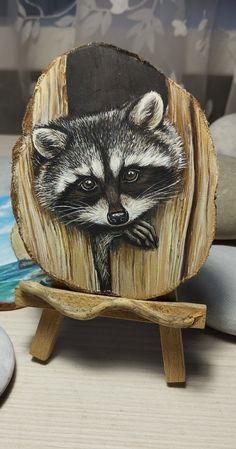 a raccoon painted on a piece of wood