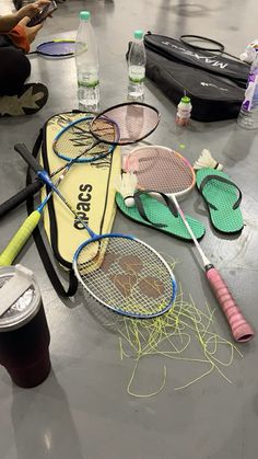 tennis racquets and other sports equipment on the floor