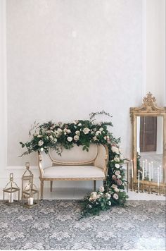 a white couch sitting next to a mirror on top of a floor covered in flowers