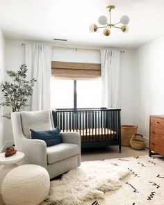 a baby's room with a crib, chair and rug