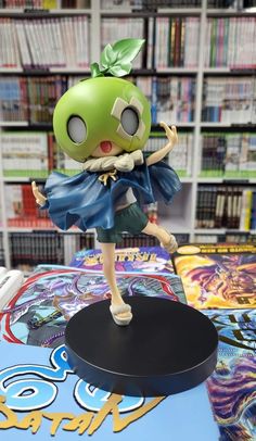 an action figure is displayed on a table in front of bookshelves and magazines