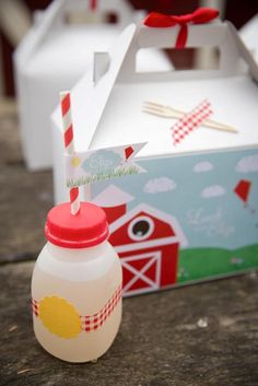 an empty milk bottle sitting next to a box with a straw in it on a table