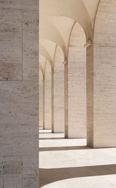 an empty walkway lined with columns and arches