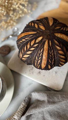 a loaf of bread sitting on top of a white plate next to a cup and saucer