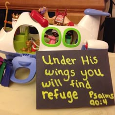 there is a sign that says under his wings you will find refuge among other toys