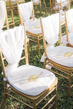 rows of gold chairs with white linens and golden fan back sashes on them