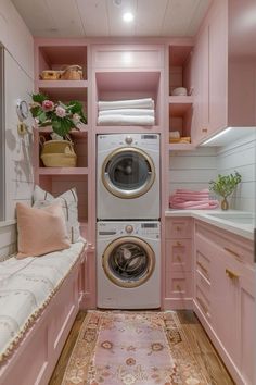 a washer and dryer in a pink laundry room with floral rugs on the floor