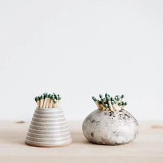 two ceramic vases with matches sticking out of them