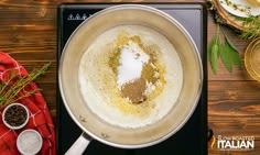 a pan filled with food sitting on top of a stove next to spices and seasoning