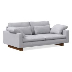 a white couch with two pillows on it's back and the arms folded down