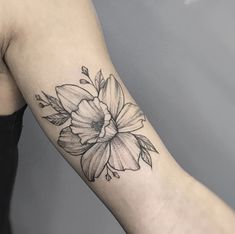 a black and white flower tattoo on the arm